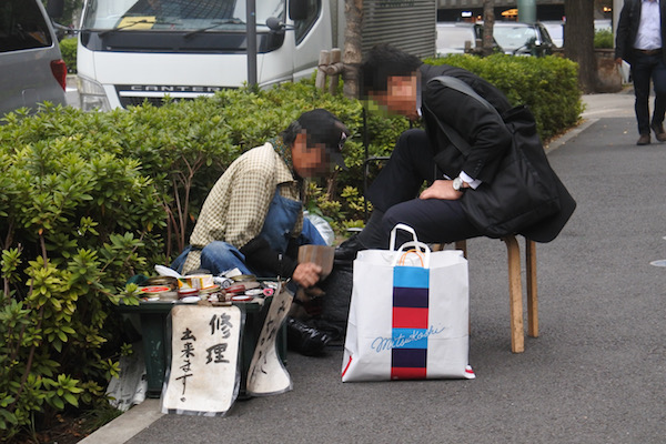 昔ながらの靴磨きの職人さんとお客さん